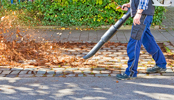 Image of a man's legs walking with leaf blower
