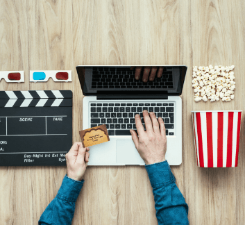 Hands holding library card and typing on a laptop