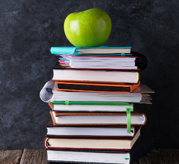 Image of a green apple on top of a stack of books