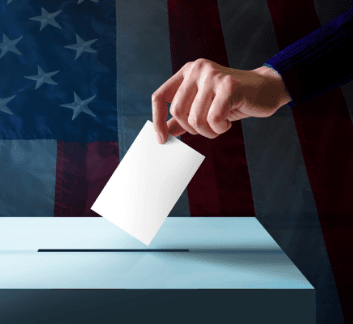 Hand droping a ballot into a voting box