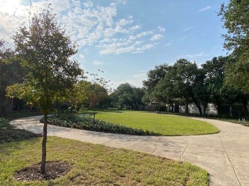 photo of a small park with green grass and walkway