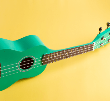 Blue ukulele on a gold background 