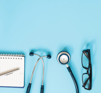 stethoscope, eyeglasses, notepad and pen on blue background