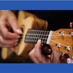 close up of someone playing a ukelele