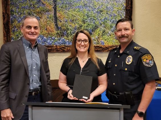 Three people smiling at the camera, the lady holding a certificate